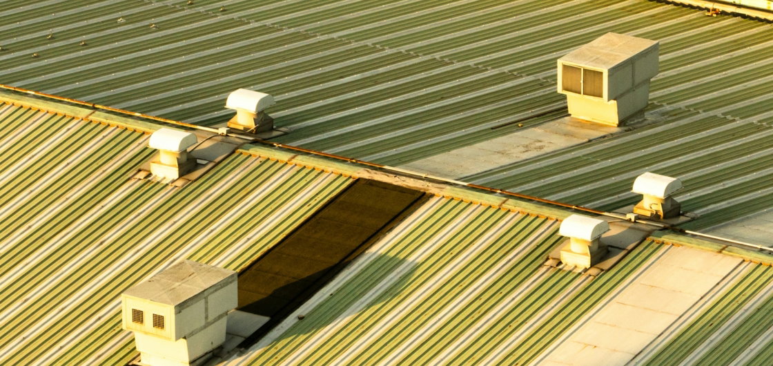 rooftop-ventilation-units-on-a-corrugated-metal-roof-.jpg Rooftop ventilation units on a corrugated metal roof.