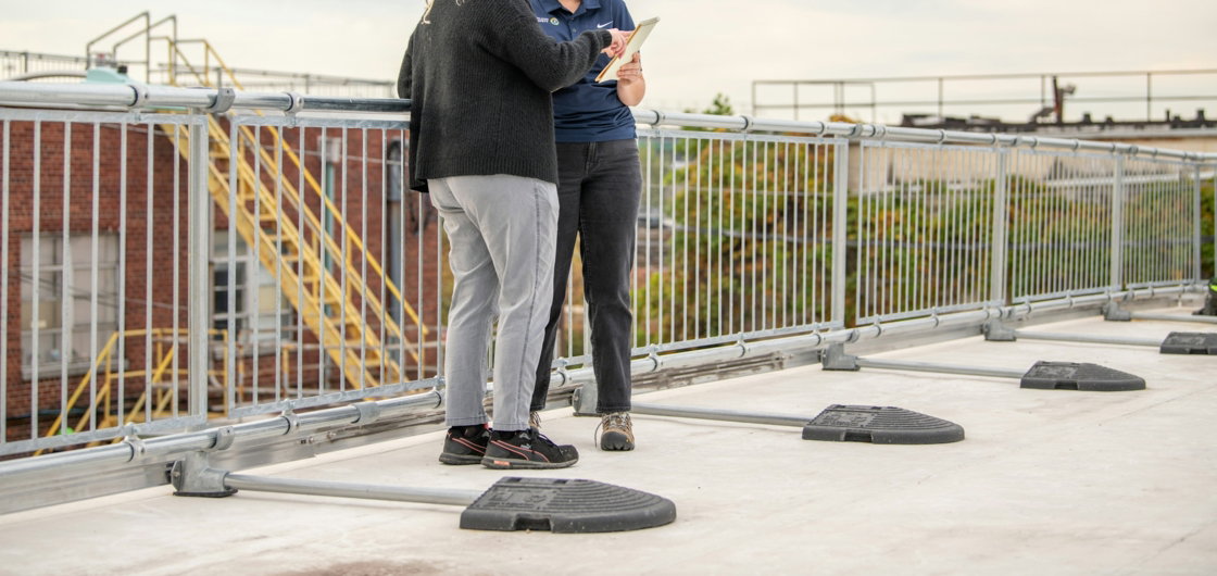 a-couple-of-people-standing-on-top-of-a-roof.jpg a couple of people standing on top of a roof